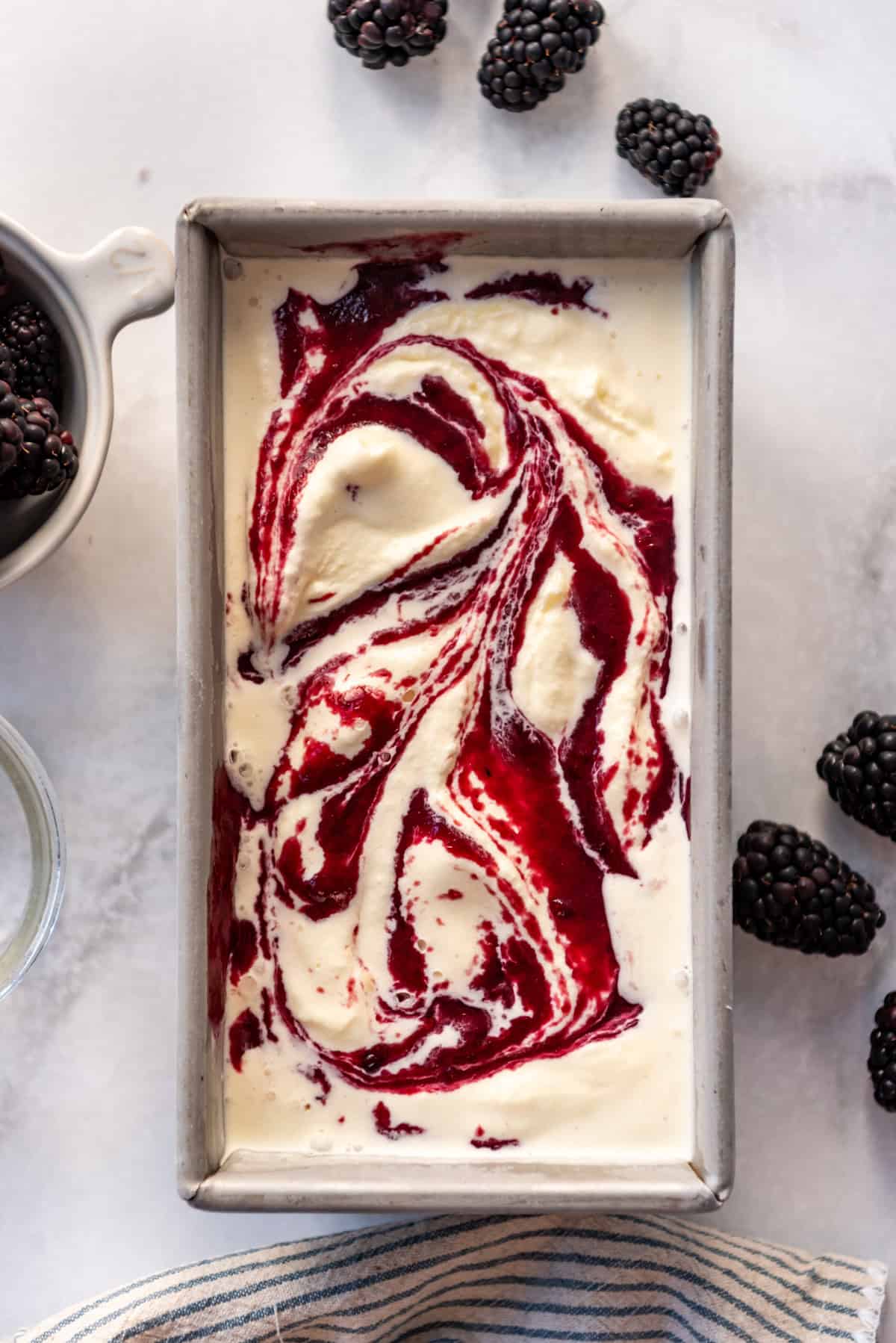 An image of homemade blackberry swirl ice cream in a container.