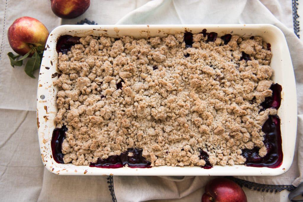 An image of a fresh fruit crumble made with nectarines and blackberries.