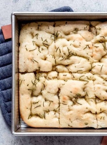 An image of a pan of easy focaccia bread cut into rectangles.