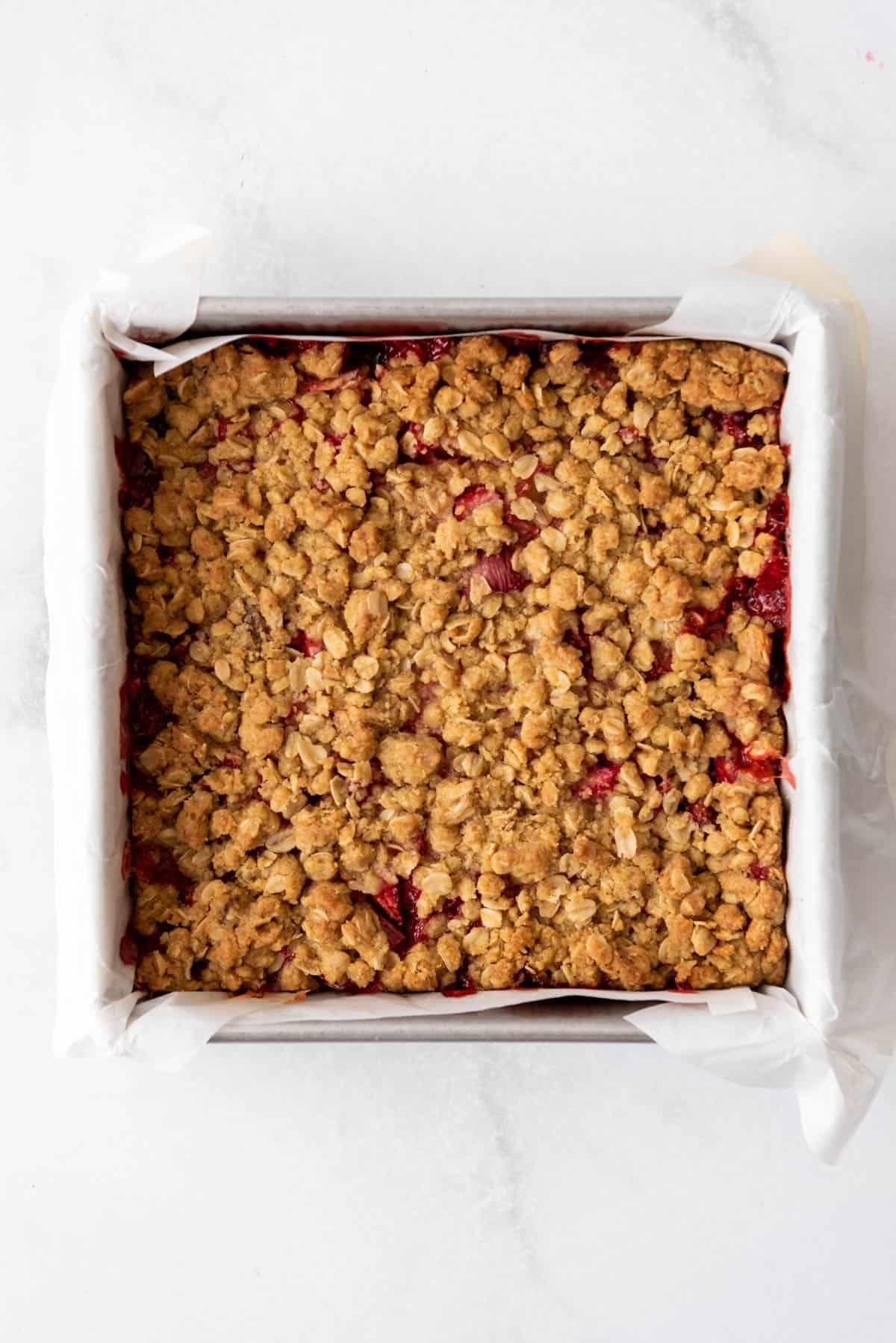 Baked strawberry rhubarb crumb bars cooling in the pan.