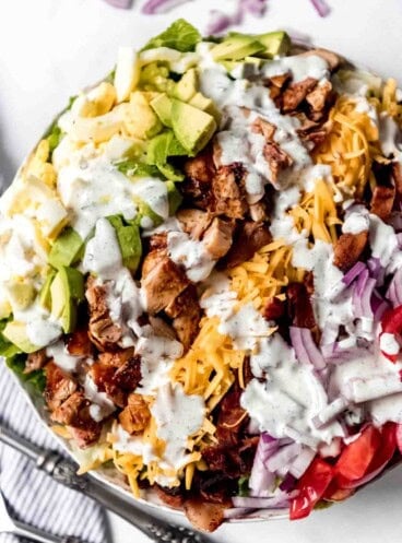 Ranch dressing drizzled over a chicken cobb salad.