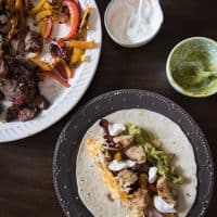 Grilled chicken and steak fajitas with sour cream and guacamole.