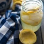 A glass of homemade lemonade with ice and lemon slices.