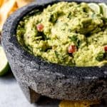 a bowl of homemade guacamole surrounded by tortilla chips