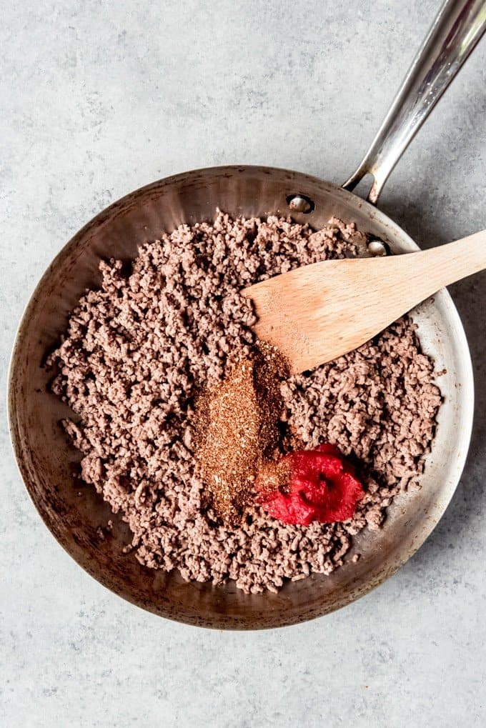 An image of browned ground beef with homemade taco spice blend and tomato paste.