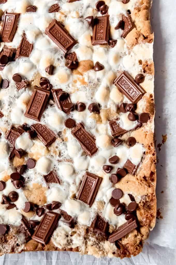 An image of s'mores cookie bars topped with toasted marshmallows and melted Hershey's chocolate.