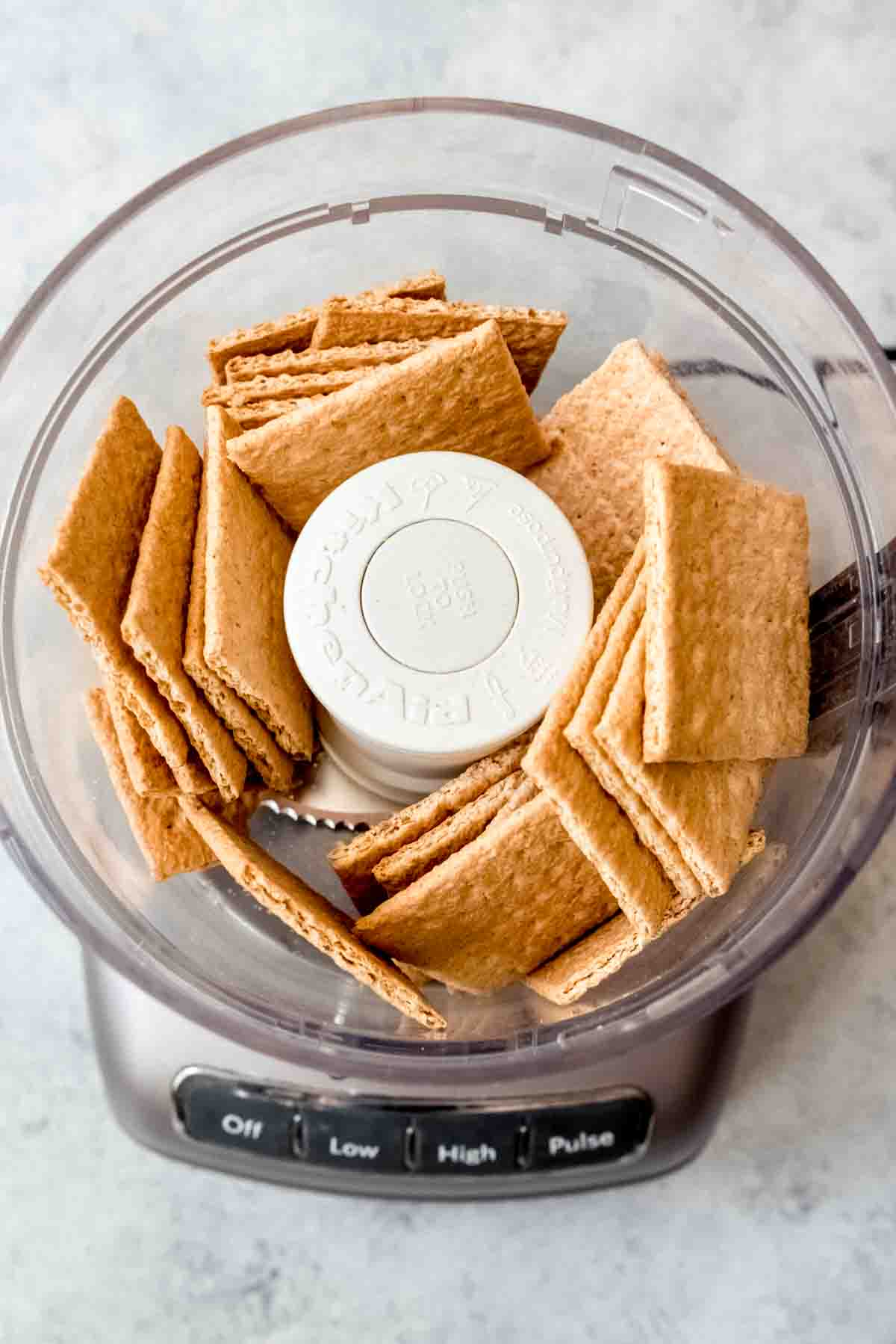 An image of graham crackers in a food processor to be pulsed into fine crumbs.