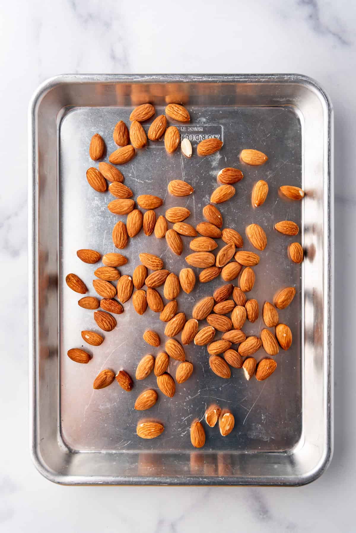 An image of whole almonds on a sheet pan for toasting.