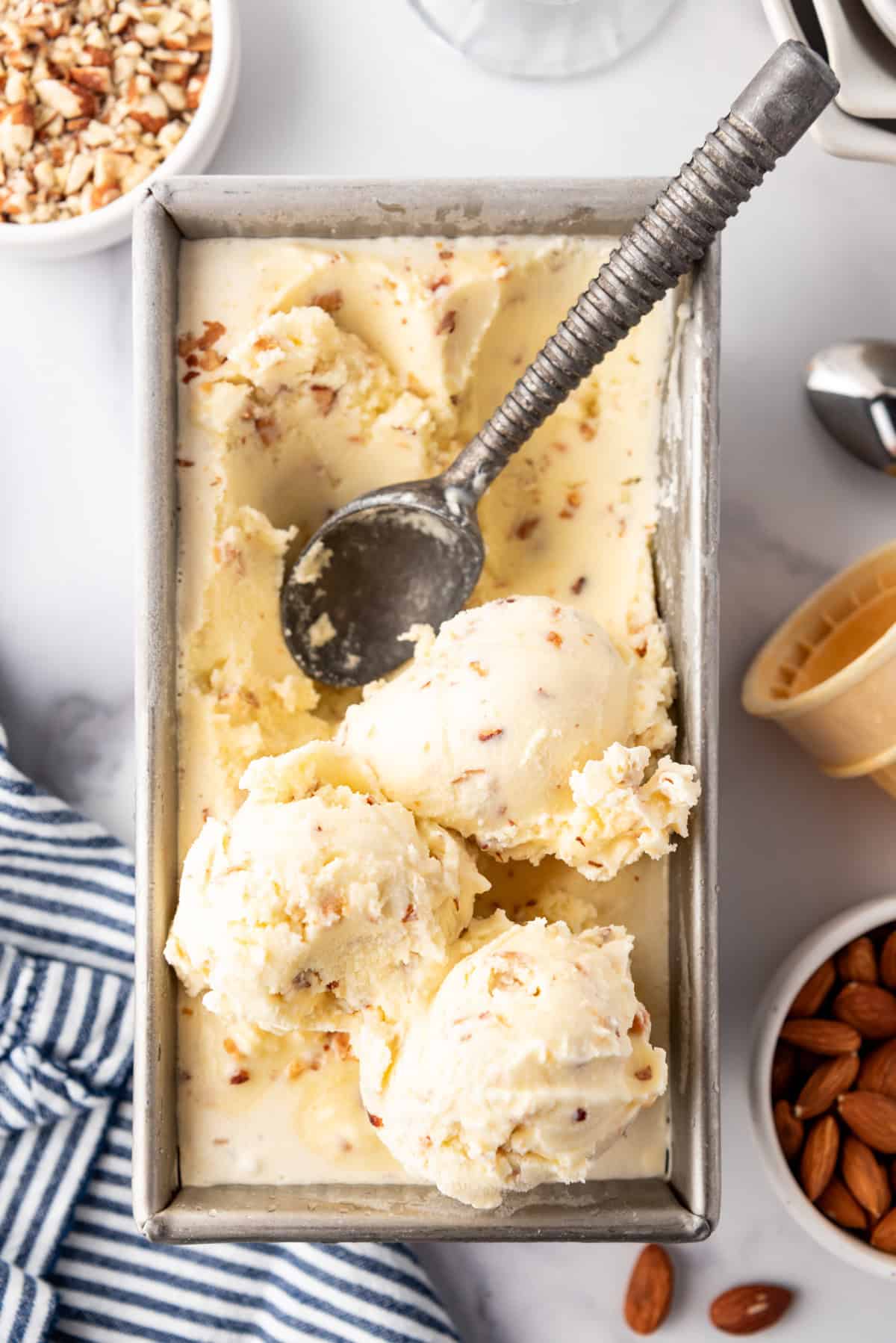 An overhead image of homemade toasted almond ice cream in a pan.