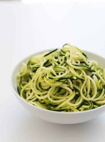 Zucchini noodles in a white bowl.