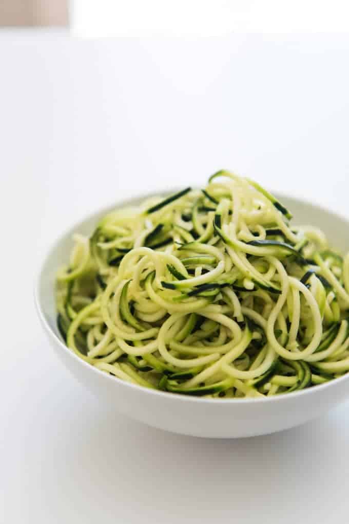 A white bowl filled with zucchini noodles.