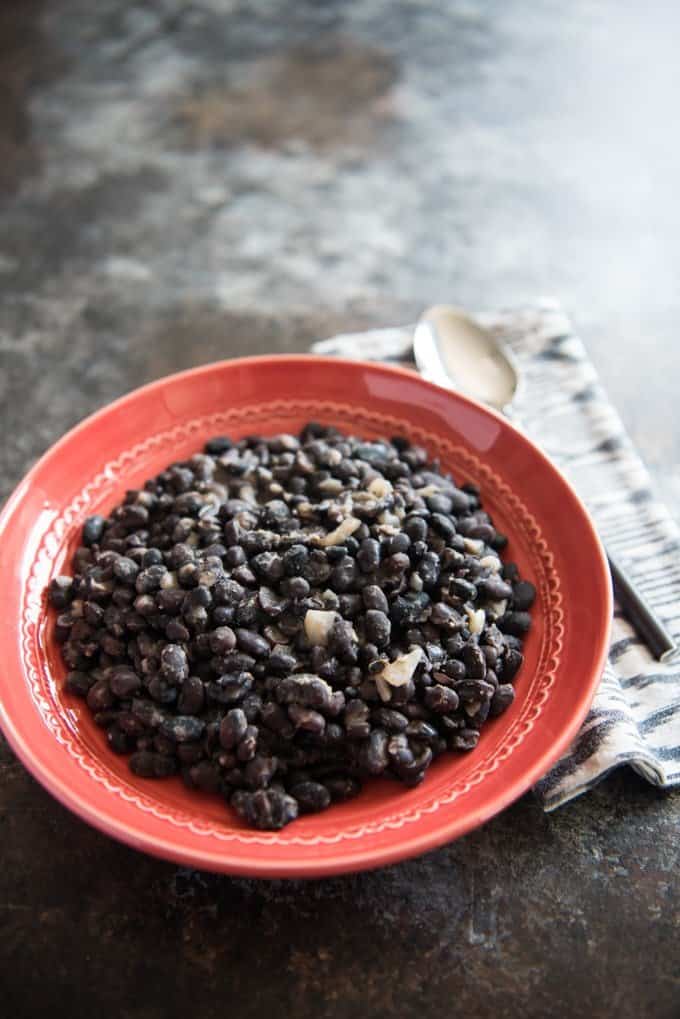 Brazilian black beans in an orange bowl.