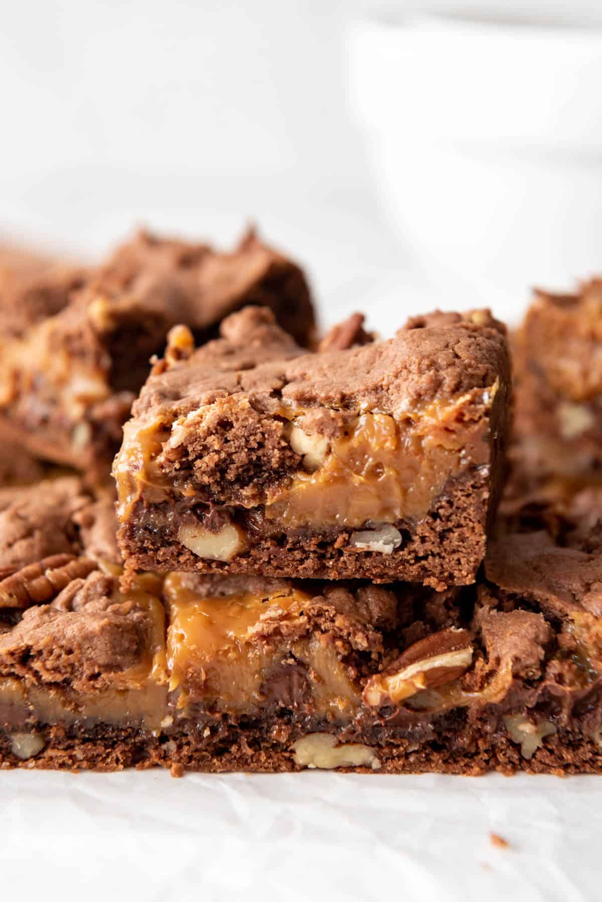 A close image of layers of caramel, brownie, and pecan.