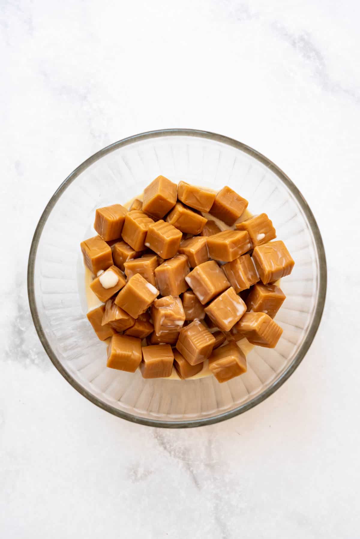 Caramels and evaporated milk in a glass bowl.