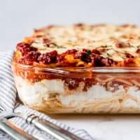 An image of a baked spaghetti casserole in a glass baking dish.
