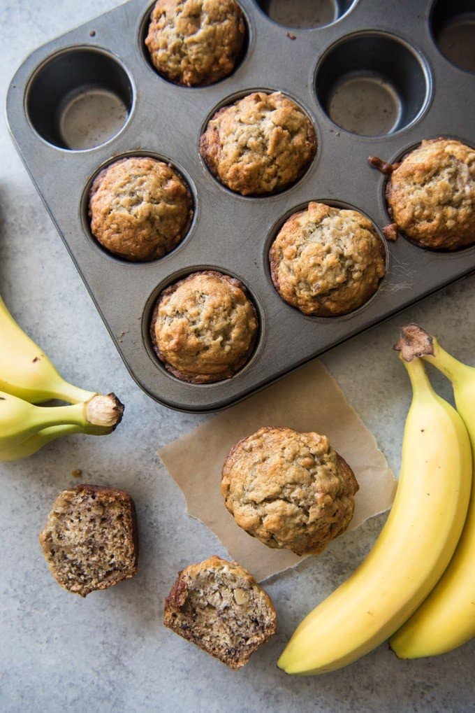 a baking pan with walnut banana muffins and bananas off to the sides