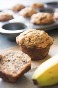 banana walnut muffins in front of a muffin tin