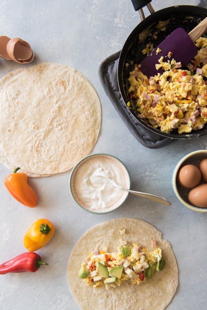 preparing and filling breakfast burritos with the various components in this image