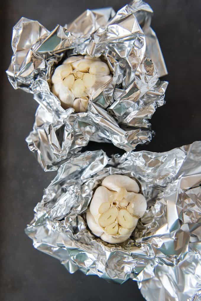 two heads of garlic with ends cut off wrapped in foil