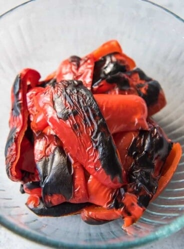 a glass bowl filled with roasted red peppers