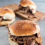Pulled pork sandwiches on sesame seed topped buns.