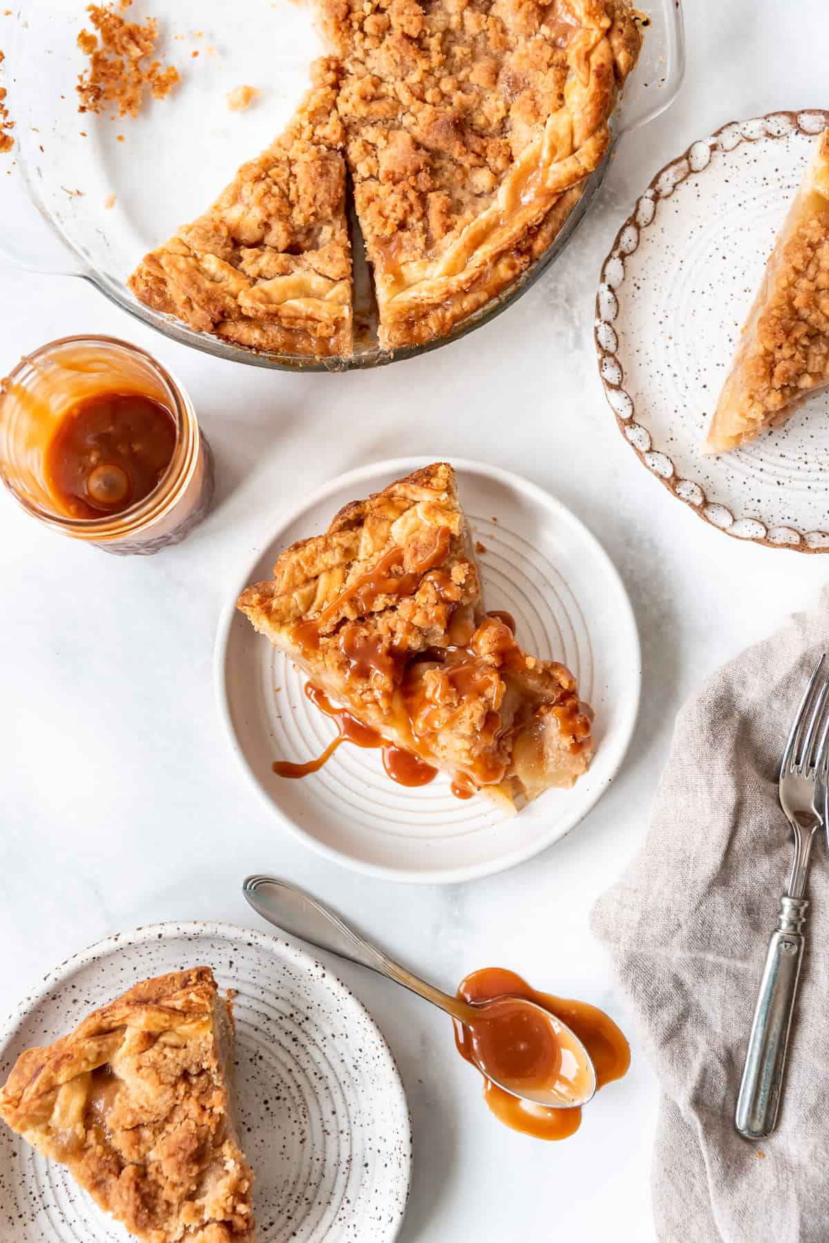 An overhead image of three slices of pear pie on plates next to the rest of the pie.