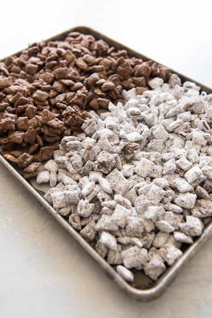 a baking sheet with white and chocolate puppy chow for halloween mix