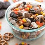 halloween chex mix in a bowl with ingredients scattered around