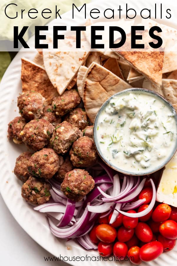 A Greek mezze platter with meatballs, onions, tomatoes, pita, and tzatziki sauce with text overlay.