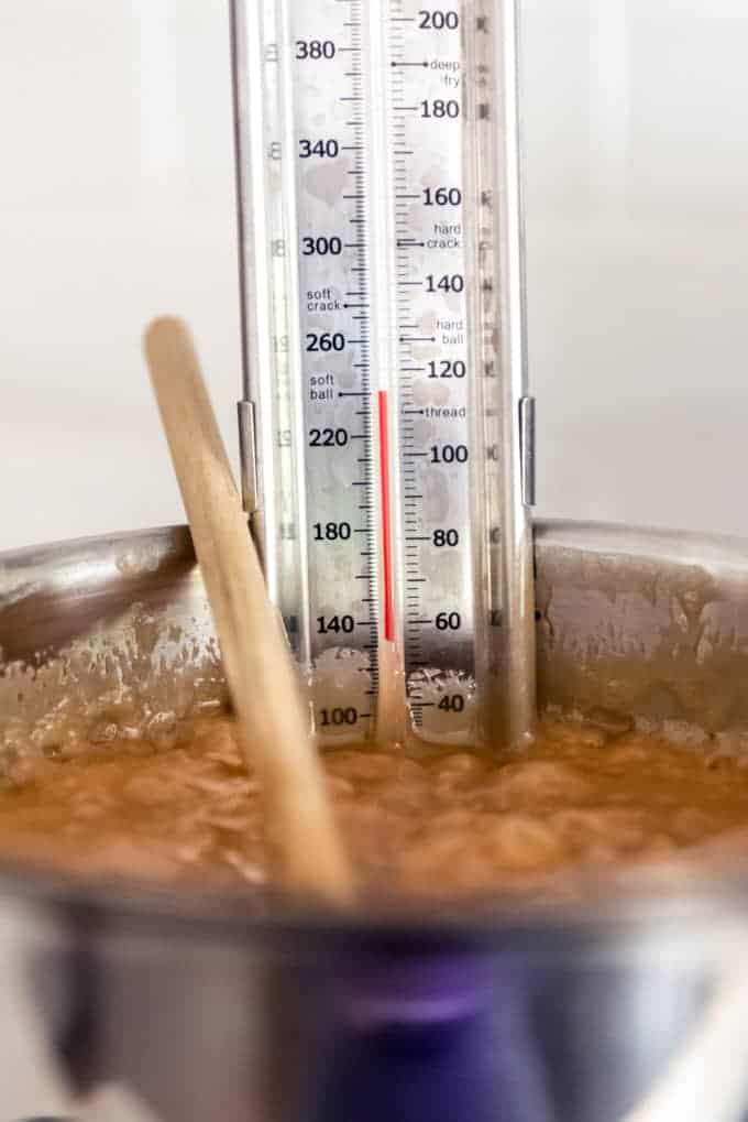 An image of a candy thermometer showing that a pot of caramel has reached soft ball stage at 240 degrees Fahrenheit.