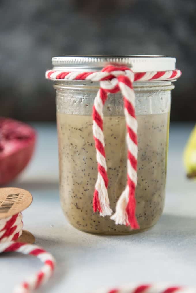 a mason jar filled with poppyseed dressing and tied with red and white rope around the rim