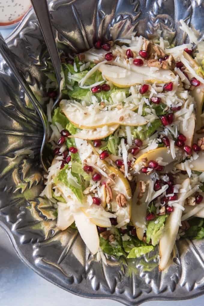 a bowl of salad with pomegranate seeds and cheese among other ingredients