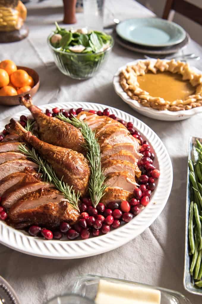 a sliced turkey with cranberries and other food dishes placed around it