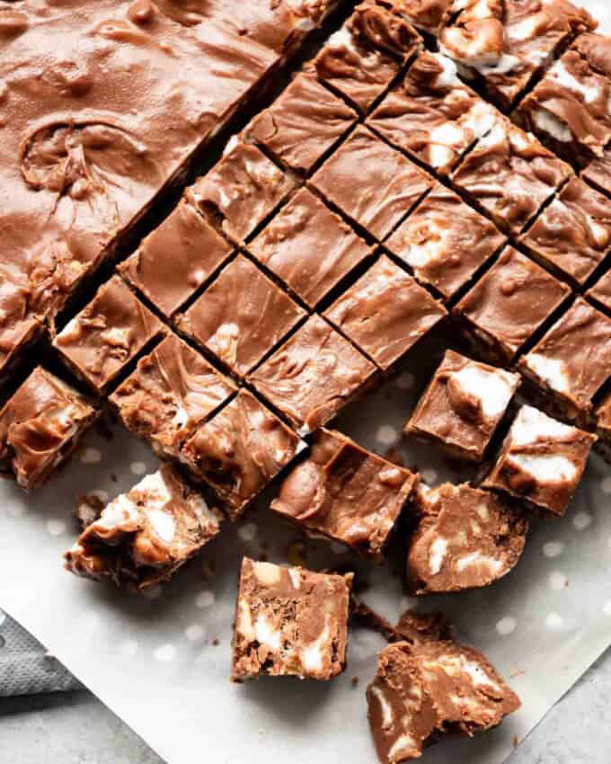 Rocky road fudge chopped into small squares on parchment paper.