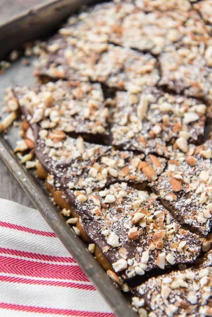 An image of broken up homemade english toffee covered in toasted almonds and semi-sweet chocolate.