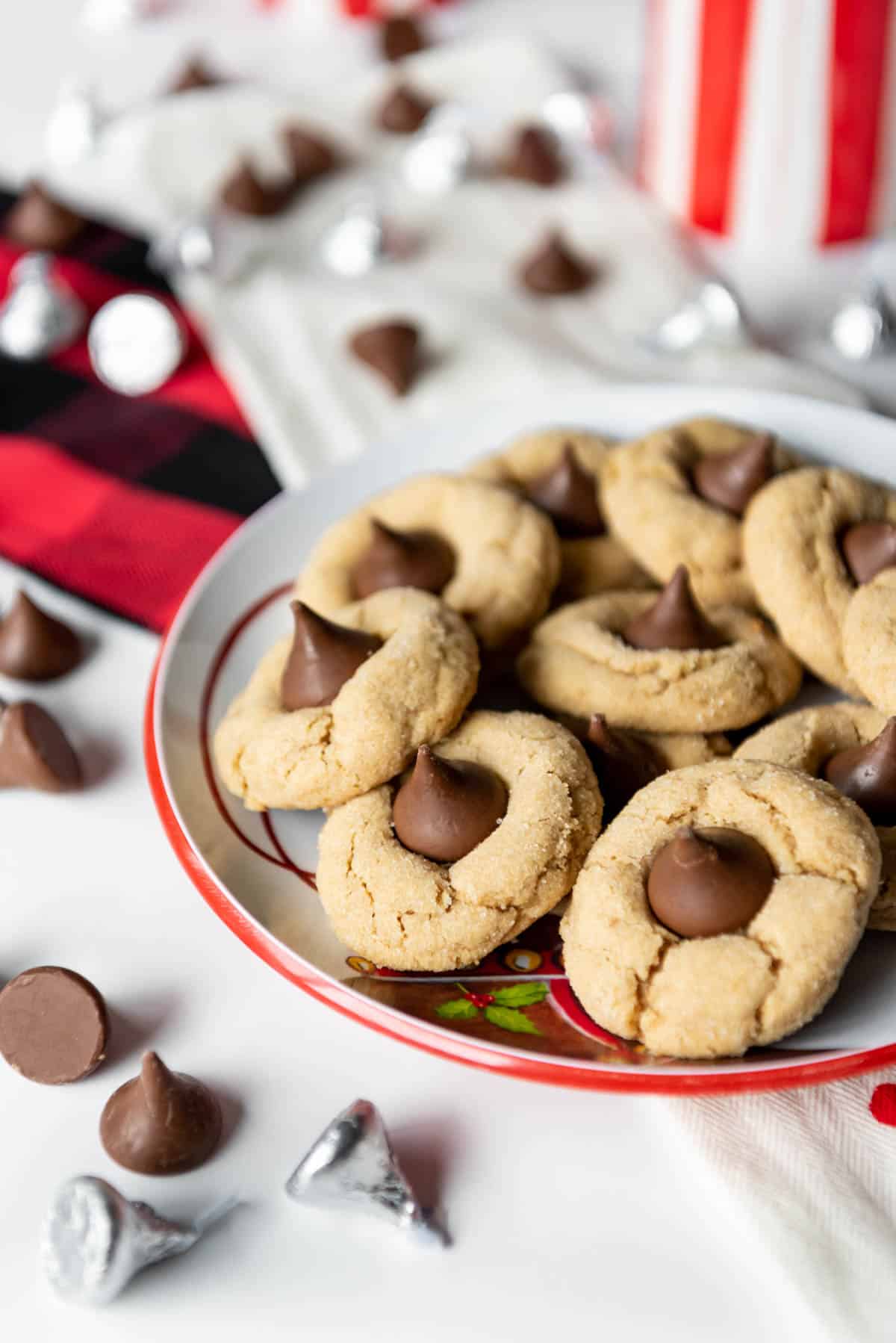 Peanut butter blossom cookies on a plate with hershey kisses around them.