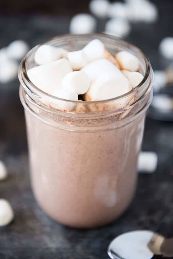 a close shot of cocoa in a mason jar topped with large and small arshmallows