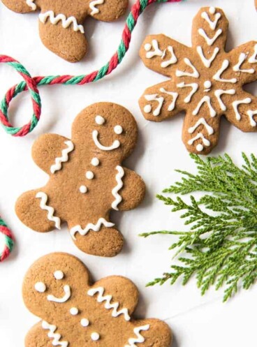 Gingerbread Men Cookies next to a string of yarn and greenery