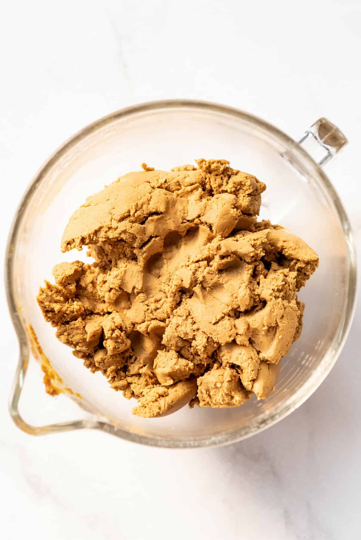 Soft gingerbread cookie dough in a glass mixing bowl.