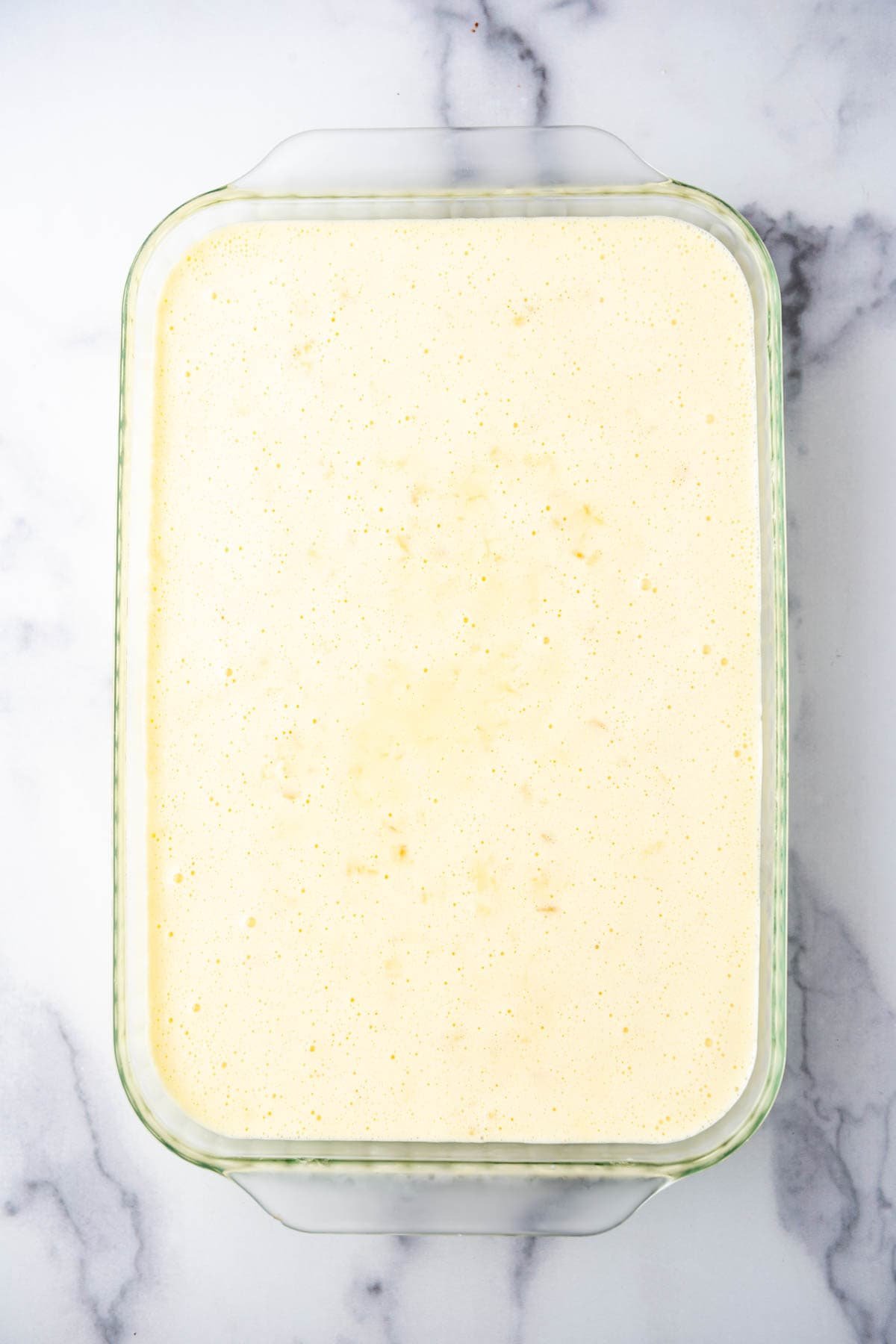 An overhead image of a layer of lemon jell-o in a glass baking dish. - 6