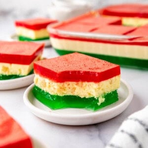 An image of a piece of red, white, and green jello on a plate. - 10