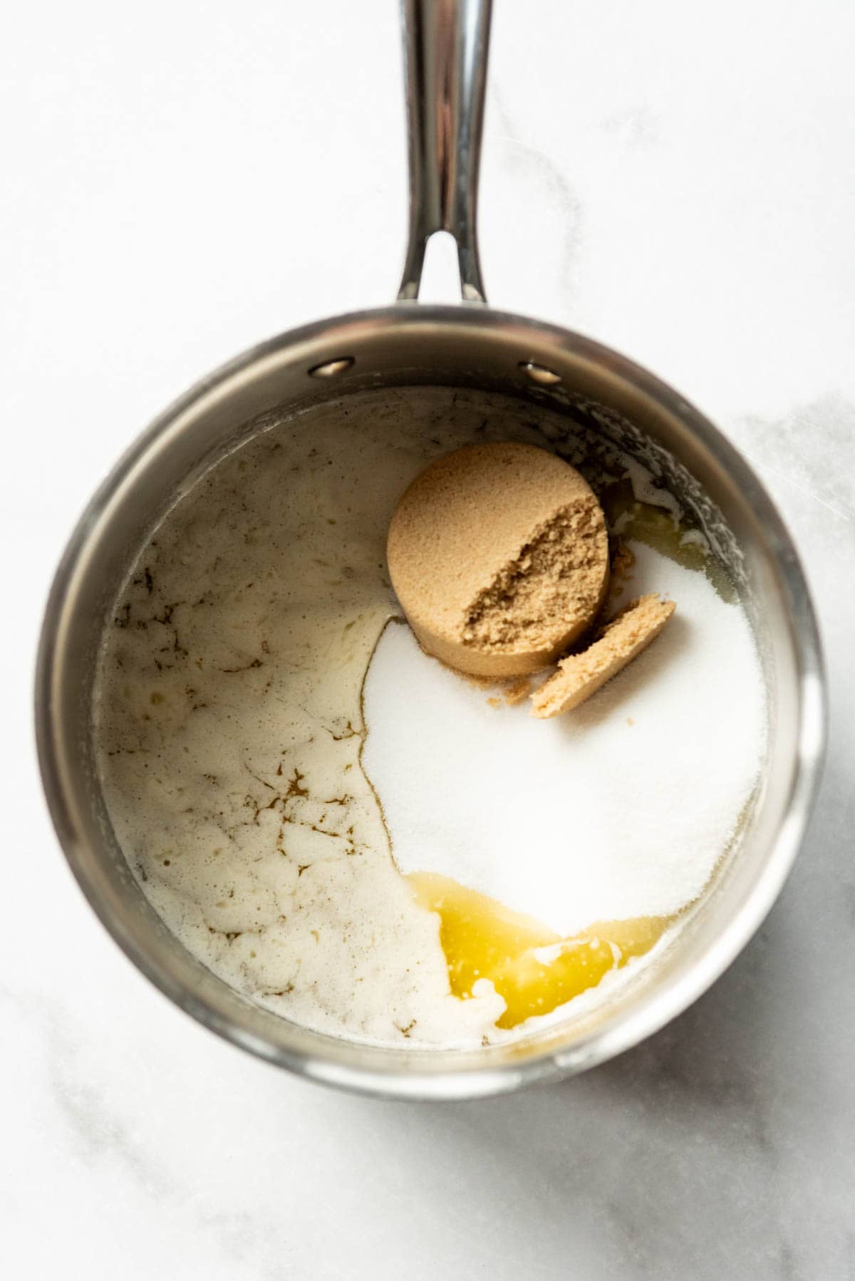 Adding sugars to melted butter in a medium saucepan to make english toffee.