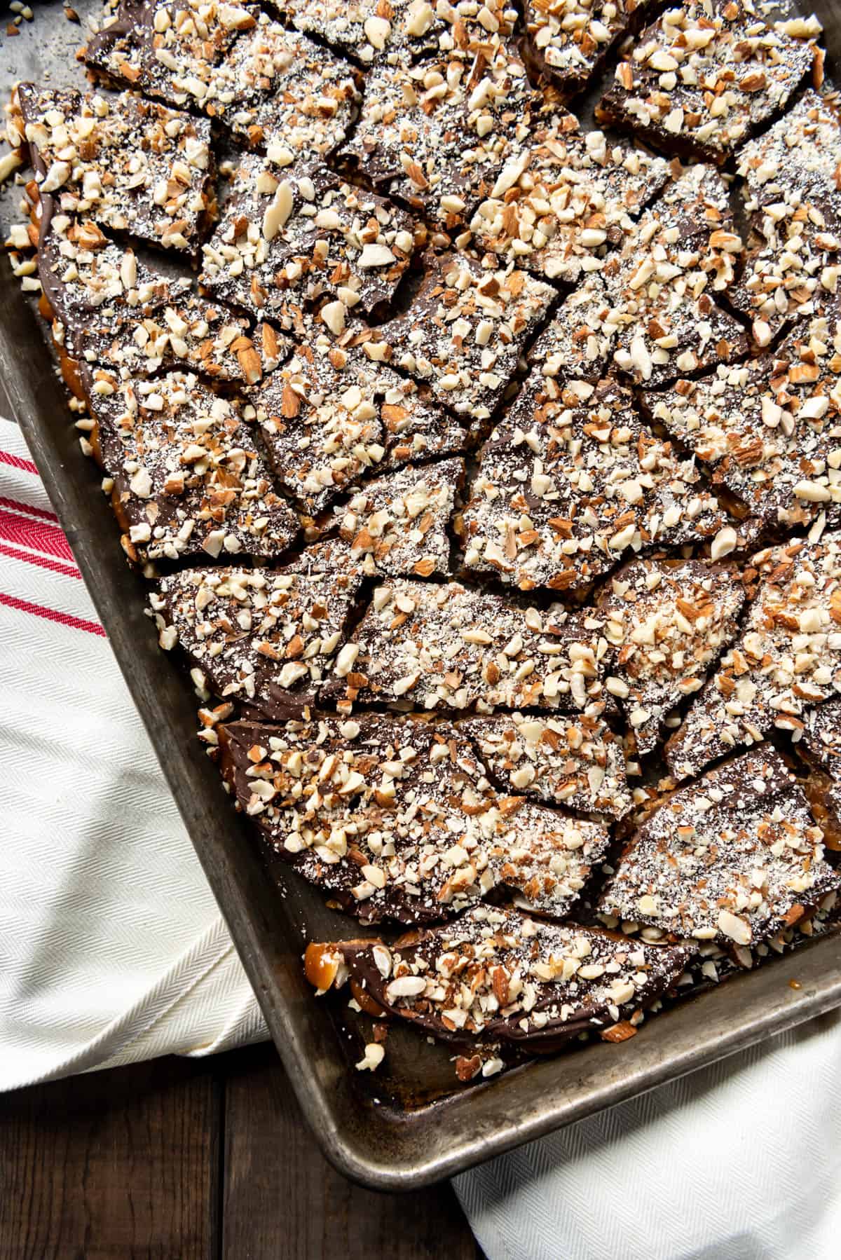 An image of broken up homemade english toffee covered in toasted almonds and semi-sweet chocolate.