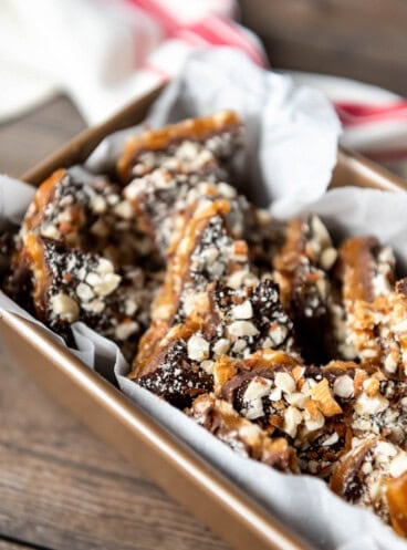 a baking dish filled with parchment paperand broken up pieces of grandma nash's english toffee