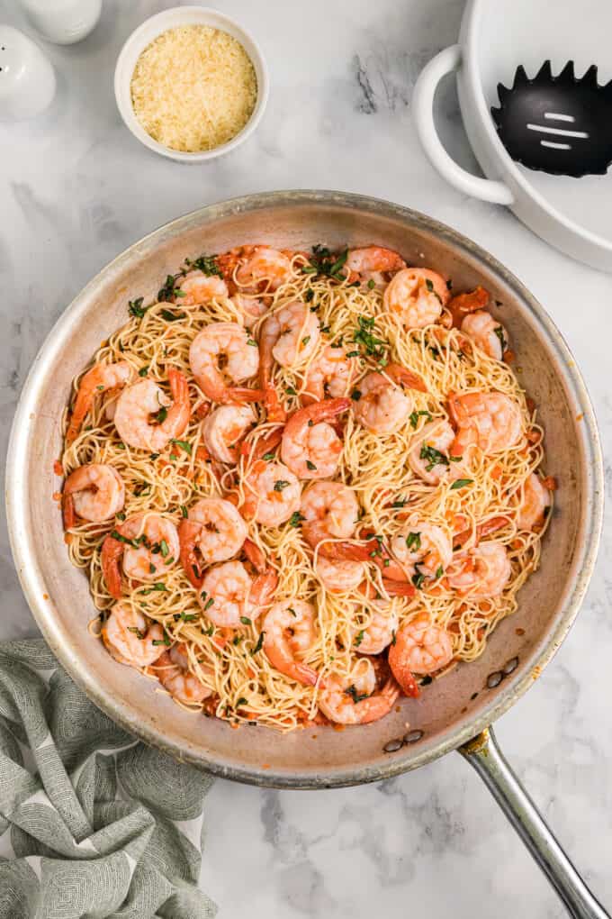 Cooked shrimp and pasta in a large skillet.