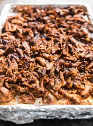a foil lined baking sheet with shredded pork on it
