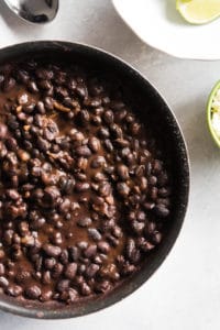 an aerial view of a skillet containing black beans
