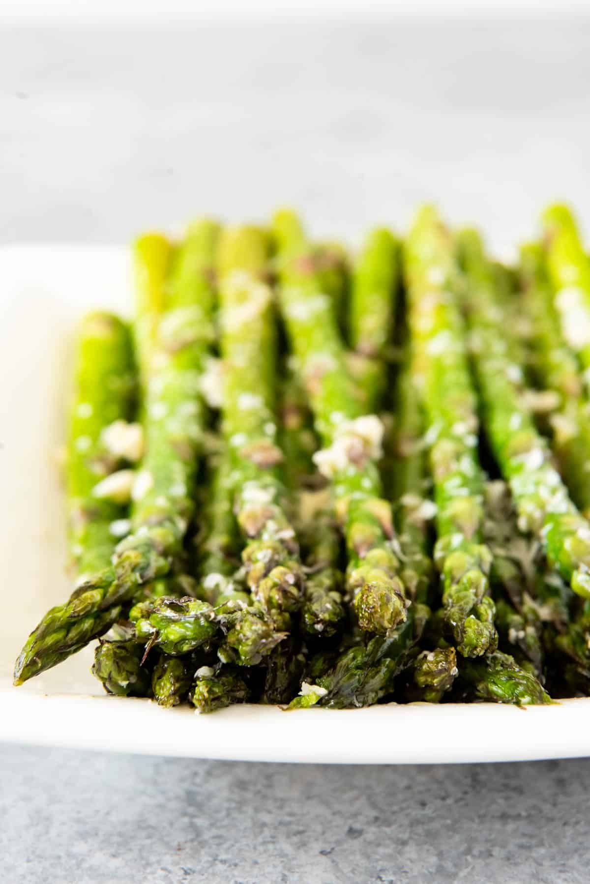 A plate with rows of asparagus topped with cheese.