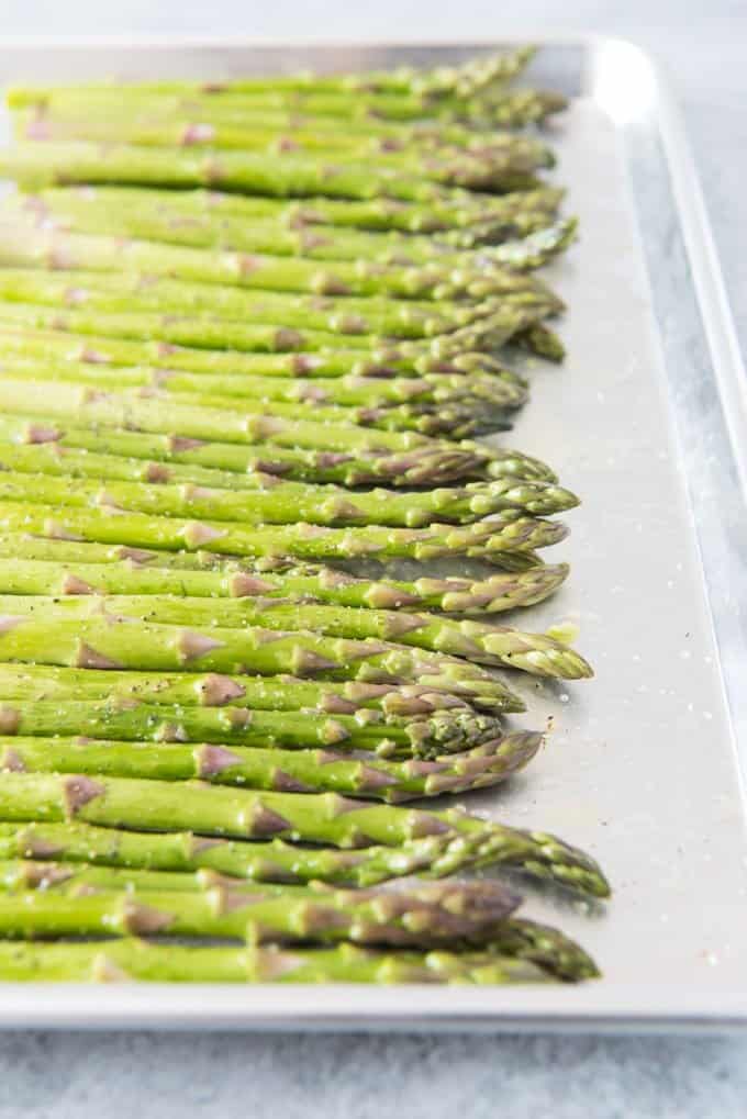 a close angled shot of asparagus on a baking sheet