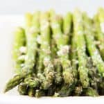 a plate with rows of asparagus topped with cheese